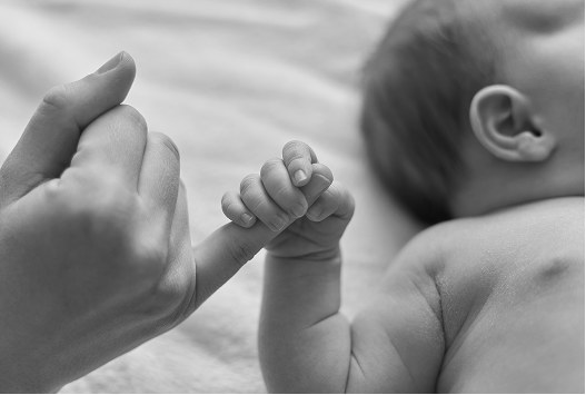 A mother holding her newborn's hand